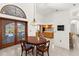 Dining area features a wood table, arched windows, and access to a kitchen at 3772 Woodridge Pl, Palm Harbor, FL 34684