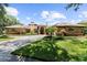 A charming single story brick home featuring arched windows, tile roof, and an inviting circular driveway at 3772 Woodridge Pl, Palm Harbor, FL 34684
