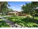 Attractive brick home with a three-car garage sits on a beautifully landscaped lot with mature trees at 3772 Woodridge Pl, Palm Harbor, FL 34684