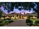 Stunning brick home features a large driveway, three-car garage, lush lawn, and a lovely arched entryway at 3772 Woodridge Pl, Palm Harbor, FL 34684