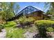 Beautiful view of a screen enclosed lanai and lush landscaping at 3772 Woodridge Pl, Palm Harbor, FL 34684
