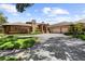 Beautiful brick home boasts a three-car garage, curved driveway, mature trees, and manicured landscaping at 3772 Woodridge Pl, Palm Harbor, FL 34684