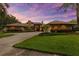 Wide angle view of sprawling brick house with lush green lawn and circular driveway at 3772 Woodridge Pl, Palm Harbor, FL 34684