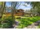Brick home showing a screened-in lanai, manicured lawn, and mature landscaping at 3772 Woodridge Pl, Palm Harbor, FL 34684