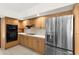 Modern kitchen with stainless steel appliances, including a double oven, and light wood cabinets at 3772 Woodridge Pl, Palm Harbor, FL 34684