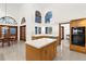 Open kitchen flows to dining area with island, modern appliances, and arch-topped windows at 3772 Woodridge Pl, Palm Harbor, FL 34684
