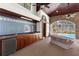 Covered outdoor kitchen area with sink, mini-refrigerator, and pool views at 3772 Woodridge Pl, Palm Harbor, FL 34684