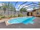 Sparkling pool and spa surrounded by a brick patio and screened-in lanai at 3772 Woodridge Pl, Palm Harbor, FL 34684