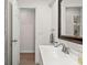 Bright bathroom featuring a white vanity, neutral walls, a shower with a glass door, and wood-look floors at 39 Bishop Creek Dr, Safety Harbor, FL 34695