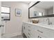 Bathroom with dual sinks, a large mirror, and modern hardware at 39 Bishop Creek Dr, Safety Harbor, FL 34695