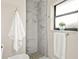 Modern bathroom featuring a walk-in shower with marble-look tile and contrasting grout at 39 Bishop Creek Dr, Safety Harbor, FL 34695