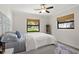 Bright bedroom featuring two windows, wood-look floors, a ceiling fan, and a comfortable bed at 39 Bishop Creek Dr, Safety Harbor, FL 34695