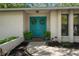 Inviting home entrance featuring a bright blue double-door with wreaths and manicured landscaping at 39 Bishop Creek Dr, Safety Harbor, FL 34695