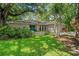 Inviting home exterior with lush lawn and mature landscaping, enhanced by a vibrant blue double-door entrance at 39 Bishop Creek Dr, Safety Harbor, FL 34695