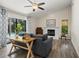 Cozy living room featuring a stone fireplace, a ceiling fan, and sliding glass doors to the pool at 39 Bishop Creek Dr, Safety Harbor, FL 34695