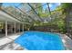 Screened-in pool with clear blue water, and an outdoor seating area at 39 Bishop Creek Dr, Safety Harbor, FL 34695
