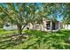 Large backyard with lush green grass, a large shade tree, and a white fence at 406 Laguna Mill Dr, Ruskin, FL 33570