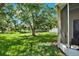 A serene backyard featuring a large shade tree, a well-manicured lawn, and a view of the pond at 406 Laguna Mill Dr, Ruskin, FL 33570