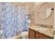 Bathroom showcasing a granite countertop, a patterned shower curtain, and a round mirror at 406 Laguna Mill Dr, Ruskin, FL 33570