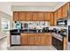 Bright, open kitchen featuring a granite countertop, stainless steel appliances, and wood cabinets at 406 Laguna Mill Dr, Ruskin, FL 33570