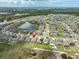 Aerial view showcases the home's location near a pond and in a tranquil community with lush trees at 4485 Eternal Prince Dr, Sun City Center, FL 33573