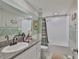 Bright bathroom with granite counter, vanity, and shower-tub combo with patterned curtain at 4485 Eternal Prince Dr, Sun City Center, FL 33573