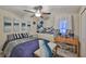 Well-lit bedroom featuring unique artwork, ceiling fan, and a comfortable bench near the natural light filled window at 4485 Eternal Prince Dr, Sun City Center, FL 33573