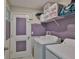 Laundry room including washer and dryer, storage shelf and purple accent wall at 4485 Eternal Prince Dr, Sun City Center, FL 33573