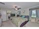 Relaxing primary bedroom featuring a ceiling fan, a window with view, and a comfortable seating area at 4485 Eternal Prince Dr, Sun City Center, FL 33573