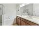 Bright bathroom featuring double sinks, tile floors, a soaking tub, and a separate shower at 518 Winthrop Dr, Spring Hill, FL 34609