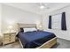 Bright bedroom with a queen bed, side tables, lamps, and a window with blue curtains at 518 Winthrop Dr, Spring Hill, FL 34609