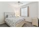 Bright bedroom with ceiling fan, carpet flooring, floral comforter on bed, and a side table at 518 Winthrop Dr, Spring Hill, FL 34609
