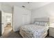 This bedroom features gray carpet, a ceiling fan and closet along with a bed with a floral comforter at 518 Winthrop Dr, Spring Hill, FL 34609