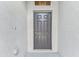 Close-up view of a solid front door with a textured exterior wall finish at 518 Winthrop Dr, Spring Hill, FL 34609