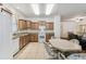 Well-lit kitchen featuring wood cabinets, tile floors, granite countertops, and white appliances at 518 Winthrop Dr, Spring Hill, FL 34609