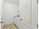 Bright laundry room featuring neutral tile floor with white washer and dryer and door at 518 Winthrop Dr, Spring Hill, FL 34609