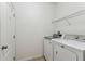 Laundry room featuring tile flooring, a door, metal shelving, a washer, and a dryer at 518 Winthrop Dr, Spring Hill, FL 34609