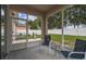 Covered patio with a gas grill, furniture and a view of the lush green lawn and the white fence at 518 Winthrop Dr, Spring Hill, FL 34609