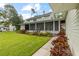 Spacious back yard featuring a screened-in porch, manicured lawn, and colorful landscaping at 523 2Nd Sw Ave, Lutz, FL 33548
