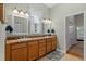 Bathroom with double sinks, wooden cabinets, decorative mirrors, and neutral color scheme at 523 2Nd Sw Ave, Lutz, FL 33548