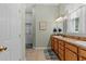 Bright bathroom with double sinks, wooden cabinets, and a window for natural light at 523 2Nd Sw Ave, Lutz, FL 33548