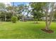 Spacious front yard with mature trees enhancing this home's curb appeal at 523 2Nd Sw Ave, Lutz, FL 33548