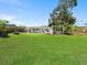 Large green back yard with white home, landscaping, and wood fence at 5514 7Th N Ave, St Petersburg, FL 33710