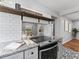 Modern kitchen features granite countertops, stainless steel range, stylish backsplash, and open shelving at 5514 7Th N Ave, St Petersburg, FL 33710