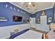 Bedroom with wood-look vinyl flooring, blue walls, ceiling fan and the name 'Jackson' on the wall at 5710 Tortoise Pl, Apollo Beach, FL 33572