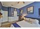 Well lit bedroom with blue walls, a ceiling fan, and wood-look vinyl flooring at 5710 Tortoise Pl, Apollo Beach, FL 33572