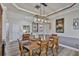 Formal dining room has wainscoting and an elegant light fixture above the wooden table at 5710 Tortoise Pl, Apollo Beach, FL 33572