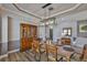 Formal dining room featuring wood floors, wainscoting, and a modern chandelier at 5710 Tortoise Pl, Apollo Beach, FL 33572