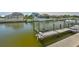 Dock on the canal with boat lift featuring composite decking and green pilings at 5710 Tortoise Pl, Apollo Beach, FL 33572