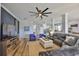 Bright living room with a large TV, comfortable seating, light wood floors, and kitchen access at 5710 Tortoise Pl, Apollo Beach, FL 33572